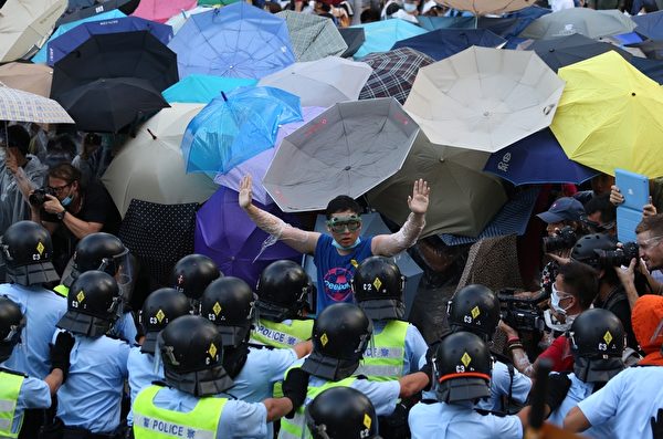2014年9月28日，民众以雨伞阻挡警方喷洒的胡椒与水柱。(aaron tam/AFP/Getty Images)