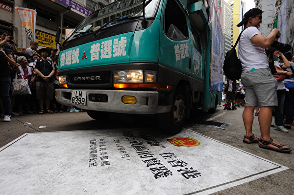 香港民間人權陣線發起的「七·一」大遊行,7月1日下午3時半前正式由銅鑼灣維多利亞公園起步,遊行隊伍中民眾以各式展板表達訴求。圖為民眾以車子輾過白皮書表達抗議之意。(文瀚林/大紀元)
香港民間人權陣線發起的「七·一」大遊行,7月1日下午3時半前正式由銅鑼灣維多利亞公園起步,遊行隊伍中民眾以各式展板表達訴求。圖為民眾以車子輾過白皮書表達抗議之意。(文瀚林/大紀元)