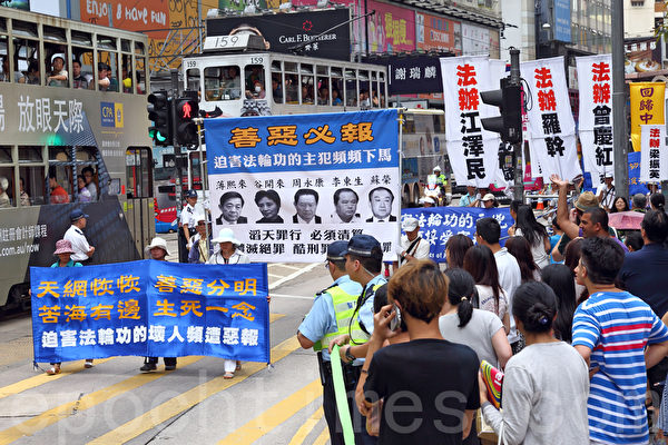 2014年7月19日,逾九百名法轮功学员在香港港岛区举行“7‧20”十五周年反迫害集会游行,呼吁各界制止中共活摘法轮功学员器官等迫害罪行,吸引众多中港民众和游客驻足观看。(潘在殊/大纪元) 2014年7月19日,逾九百名法轮功学员在香港港岛区举行“7‧20”十五周年反迫害集会游行,呼吁各界制止中共活摘法轮功学员器官等迫害罪行,吸引众多中港民众和游客驻足观看。(潘在殊/大纪元)