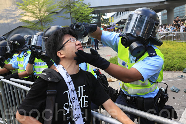 29日下午,香港政府总部前的金钟夏悫道,这位最简单的防护装置都没有的年轻人,对向他喷射胡椒喷雾的防暴警察怒吼,“为什么你要对我们这些手无寸铁的市民下手?”戴上防毒面具的防暴警察、虽然看不到面孔和表情,用手轻拍愤怒的示威者,连声说“知道,知道”,转身拿出自己的水壶,为这位他刚刚出手伤害的市民冲洗眼睛。(余钢/大纪元) 29日下午,香港政府总部前的金钟夏悫道,这位最简单的防护装置都没有的年轻人,对向他喷射胡椒喷雾的防暴警察怒吼,“为什么你要对我们这些手无寸铁的市民下手?”戴上防毒面具的防暴警察、虽然看不到面孔和表情,用手轻拍愤怒的示威者,连声说“知道,知道”,转身拿出自己的水壶,为这位他刚刚出手伤害的市民冲洗眼睛。(余钢/大纪元)