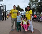 身着法轮大法T恤衫的马克‧提克纳与妻子潇潇带着两个孩子在旧金山市中心广场的一个儿童游乐场合影（唐风/大纪元）