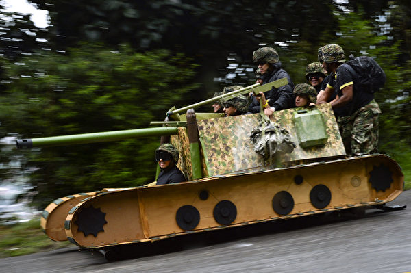 2014年10月26日，哥倫比亞麥德林舉行盛大的汽車節，參賽者駕駛自製的小車參加下坡比賽。圖為坦克造型車。（Raul ARBOLEDA/AFP） 