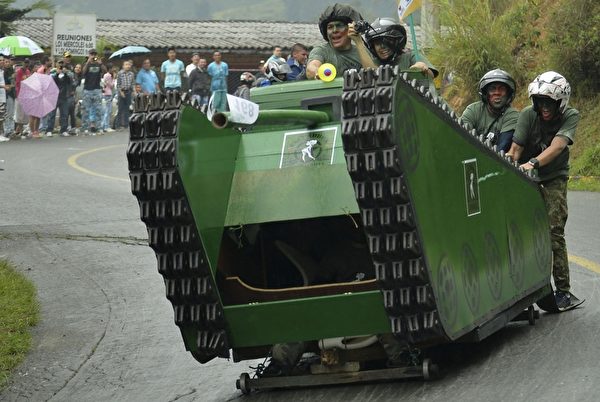 2014年10月26日，哥倫比亞麥德林舉行盛大的汽車節，參賽者駕駛自製的小車參加下坡比賽。圖為坦克造型車。（Raul ARBOLEDA/AFP） 