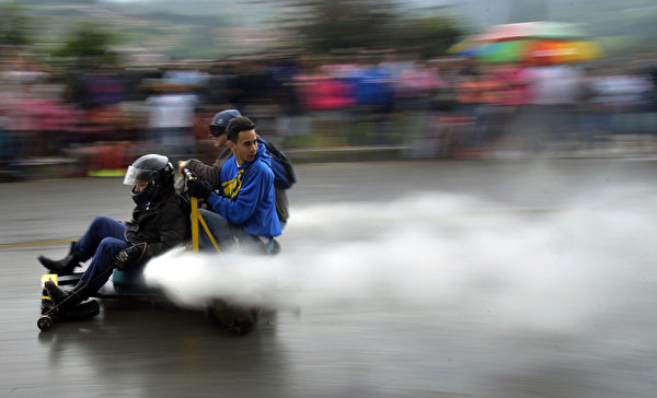 2014年10月26日，哥倫比亞麥德林舉行盛大的汽車節，參賽者駕駛自製的小車參加下坡比賽。圖為噴射車。（Raul ARBOLEDA/AFP）