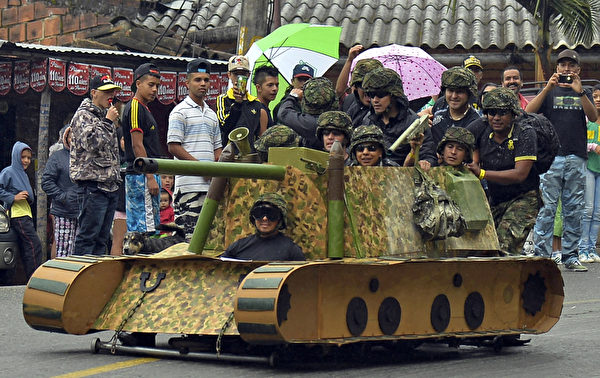 2014年10月26日，哥倫比亞麥德林舉行盛大的汽車節，參賽者駕駛自製的小車參加下坡比賽。圖為坦克造型車。（Raul ARBOLEDA/AFP）