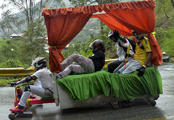 2014年10月26日，哥倫比亞麥德林舉行盛大的汽車節，參賽者駕駛自製的小車參加下坡比賽。（Raul ARBOLEDA/AFP）