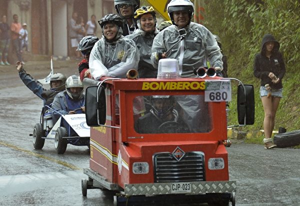 2014年10月26日，哥倫比亞麥德林舉行盛大的汽車節，參賽者駕駛自製的小車參加下坡比賽。圖為消防車。（Raul ARBOLEDA/AFP）
