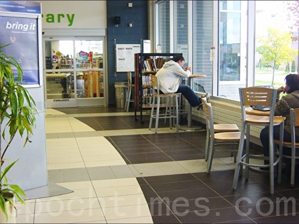 加拿大的图书馆阅览室外面的大厅是供民众自由活动的场所，在这里可以吃饭，和朋友聚会聊天，上网工作等。这是我们区的图书馆的大厅。（李文笛/大纪元）