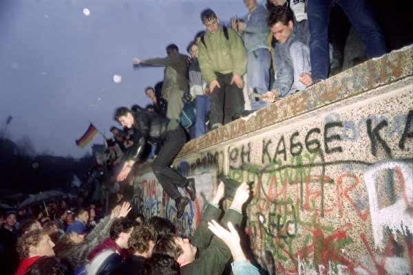 1989年12月22日,东德人在勃兰登堡门向西德柏林市民打招呼。(PATRICK HERTZOG/AFP/Getty Images) 1989年12月22日,东德人在勃兰登堡门向西德柏林市民打招呼。(PATRICK HERTZOG/AFP/Getty Images)