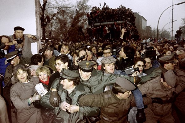 1989年11月12日,波茨坦广场的柏林墙被打开,东、西德警方控制东柏林的人潮向西德冲过去。 ( PATRICK HERTZOG/AFP/Getty Images) 1989年11月12日,波茨坦广场的柏林墙被打开,东、西德警方控制东柏林的人潮向西德冲过去。 ( PATRICK HERTZOG/AFP/Getty Images)