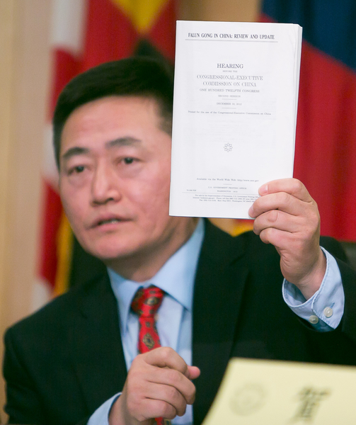 李祥春手舉美國國會及行政當局中國委員會的報告,其中收錄了他提交的中國退黨大潮報告。(李莎/大紀元) 李祥春手舉美國國會及行政當局中國委員會的報告,其中收錄了他提交的中國退黨大潮報告。(李莎/大紀元)