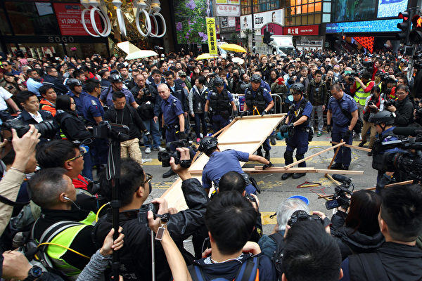 2014年12月15日,銅鑼灣佔領區,警方特別戰術小隊用鐵鉗剪斷索帶,移離鐵馬,出動電鋸鋸開大型木板,清走帳幕雜物。(潘在殊/大紀元) 2014年12月15日,銅鑼灣佔領區,警方特別戰術小隊用鐵鉗剪斷索帶,移離鐵馬,出動電鋸鋸開大型木板,清走帳幕雜物。(潘在殊/大紀元)