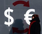 12月15日，卢布兑美元贬破60大关，最低触及1美元兑61.25卢布，刷新历史新低。图为12月3日，一名妇女路过莫斯科一家汇兑中心。（VASILY MAXIMOV/AFP/Getty Images）