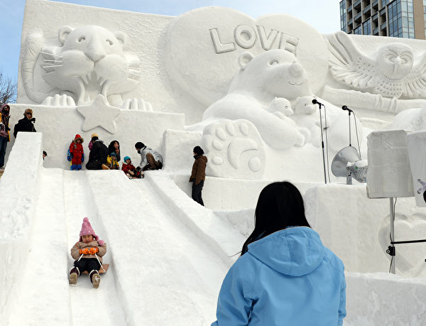 2014年2月5日,日本札幌雪祭冰雕作品旁的溜滑梯。(TOSHIFUMI KITAMURA/AFP) 2014年2月5日,日本札幌雪祭冰雕作品旁的溜滑梯。(TOSHIFUMI KITAMURA/AFP)