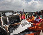 2015年1月17日，強大海流阻斷了潛水伕打撈亞航Q8501遺體的工作。圖為泗水部分打撈上岸的遺體裝上卡車。（AFP PHOTO / Juni KRISWANTO）