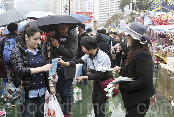 香港维园人头涌涌,有法轮功学员为市民送上小莲花表达新年祝福。(余钢/大纪元) 香港维园人头涌涌,有法轮功学员为市民送上小莲花表达新年祝福。(余钢/大纪元)