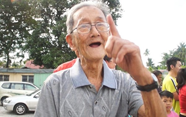 万挠老居民周先生开心的表示,他吃到这么多年来,才第一次看见,希望游行队伍明年再来。(徐长乐/大纪元) 万挠老居民周先生开心的表示,他吃到这么多年来,才第一次看见,希望游行队伍明年再来。(徐长乐/大纪元)