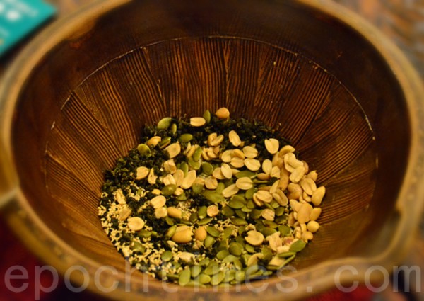 把茶叶、花生、芝麻…等食材,放进陶土烧成的“擂钵”,钵内有沟纹。(彩霞/大纪元) 把茶叶、花生、芝麻…等食材,放进陶土烧成的“擂钵”,钵内有沟纹。(彩霞/大纪元)