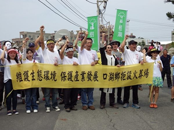 民眾手持抗議布條遊行。(廖素貞/大紀元) 民眾手持抗議布條遊行。(廖素貞/大紀元)