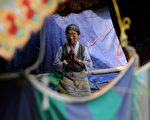 2015年5月25日強震襲擊尼泊爾已屆滿月，一位地震災民在加德滿都寺院臨時搭建的帳蓬祈禱。(Ishara S.KODIKARA/AFP/Getty Images)