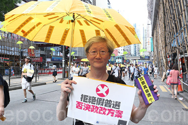 61歲的李先生手持自製的「我要真普選」黃傘,他說中共害怕民意不敢給港人真普選,認為中共政權是人民的苦難,不應存在。(蔡雯文/大紀元) 61歲的李先生手持自製的「我要真普選」黃傘,他說中共害怕民意不敢給港人真普選,認為中共政權是人民的苦難,不應存在。(蔡雯文/大紀元)
