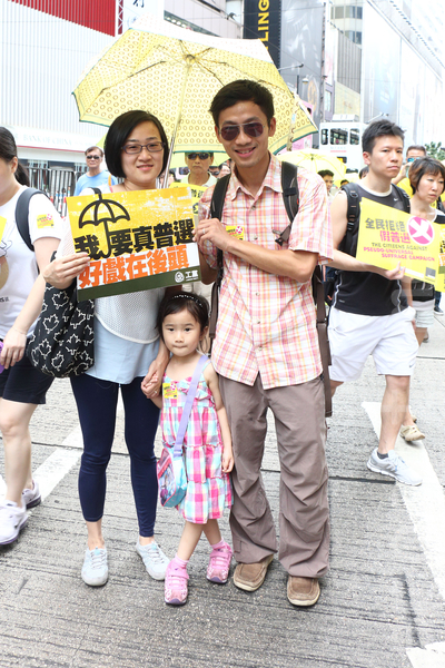 劉先生與太太帶著四歲的女兒參加遊行,希望可以為下一代爭取民主、自由和法治。他批評中央擔心權力受動搖,一直打壓港人爭取民主。(蔡雯文/大紀元) 劉先生與太太帶著四歲的女兒參加遊行,希望可以為下一代爭取民主、自由和法治。他批評中央擔心權力受動搖,一直打壓港人爭取民主。(蔡雯文/大紀元)