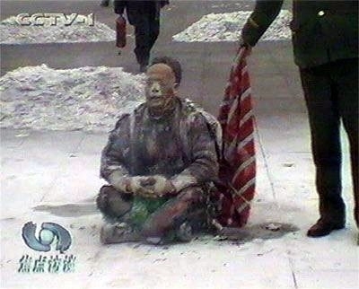 天安門自焚偽案中在王進東自焚時,警察拿著所謂的「滅火毯」,卻垂在王進東的身後,垂在下面,是在做戲,不是在救「火」。(視頻截圖) 天安門自焚偽案中在王進東自焚時,警察拿著所謂的「滅火毯」,卻垂在王進東的身後,垂在下面,是在做戲,不是在救「火」。(視頻截圖)