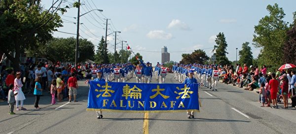 二零一五年七月一日下午,多伦多法轮功学员组成的天国乐团和腰鼓队赶场,又参加四点在大多伦多士嘉堡市举行的国庆节游行。(明慧网) 二零一五年七月一日下午,多伦多法轮功学员组成的天国乐团和腰鼓队赶场,又参加四点在大多伦多士嘉堡市举行的国庆节游行。(明慧网)