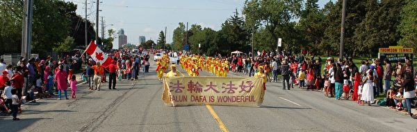 二零一五年七月一日下午,多伦多法轮功学员组成的天国乐团和腰鼓队赶场,又参加四点在大多伦多士嘉堡市举行的国庆节游行。(明慧网) 二零一五年七月一日下午,多伦多法轮功学员组成的天国乐团和腰鼓队赶场,又参加四点在大多伦多士嘉堡市举行的国庆节游行。(明慧网)
