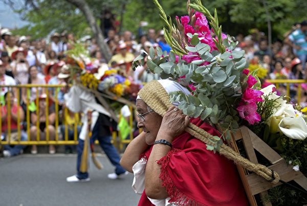 2015年8月9日，哥伦比亚鲜花节背花大游行，热闹非凡。（Raul ARBOLEDA/AFP）