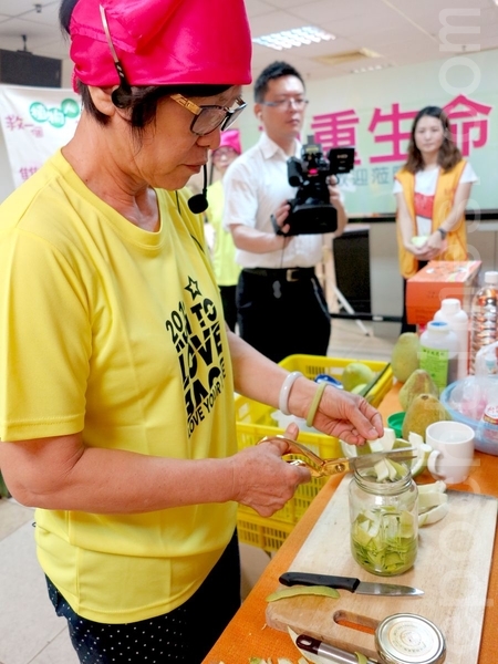 创世基金会家事达人志工徐己庭,教导民众自制柚子精油防蚊液。(李晴玳/大纪元) 创世基金会家事达人志工徐己庭,教导民众自制柚子精油防蚊液。(李晴玳/大纪元)