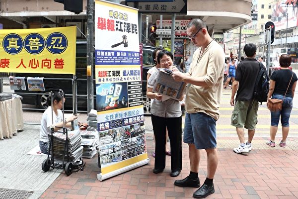 香港法轮功学员小红满脸笑容讲真相,赢得不少人签名举报江泽民。(明慧网) 香港法轮功学员小红满脸笑容讲真相,赢得不少人签名举报江泽民。(明慧网)