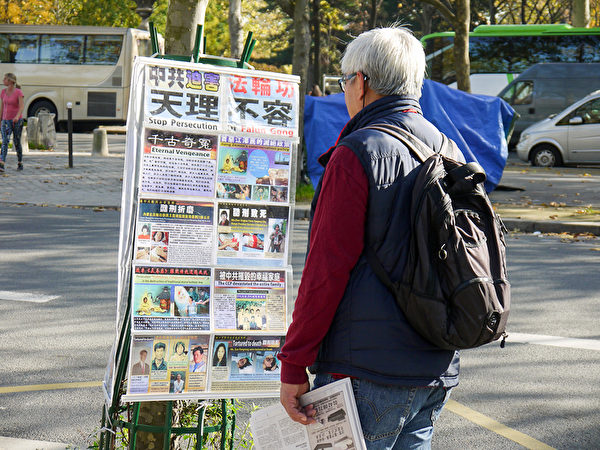 巴黎景点上,大陆游客观看法轮功真相展板。(明慧网) 巴黎景点上,大陆游客观看法轮功真相展板。(明慧网)