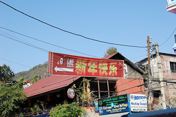 突然,出现了标准的汉字!是在一个闪亮的长条红布上,写着“新年快乐”,右边还画着两个带流苏的红灯笼。仿佛汉语是尼泊尔的国语。(作者朱瑞提供) 突然,出现了标准的汉字!是在一个闪亮的长条红布上,写着“新年快乐”,右边还画着两个带流苏的红灯笼。仿佛汉语是尼泊尔的国语。(作者朱瑞提供)