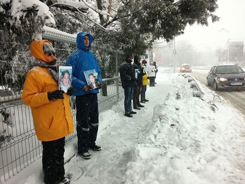学员们手持被迫害致死的法轮功学员照片,在中使馆前和平抗议(图片来源:明慧网文章《风雪中的坚守》) 学员们手持被迫害致死的法轮功学员照片,在中使馆前和平抗议(图片来源:明慧网文章《风雪中的坚守》)