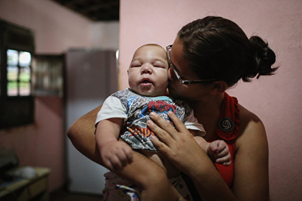 雖然茲卡感染很少導致死亡，但衛生行政部門認為這種病毒跟巴西急劇增加的新生兒缺陷（小頭畸形病）有關聯。圖為在嚴重疫區伯南布哥州出生的5個月大小腦症男嬰及其母親。（Mario Tama/Getty Images）