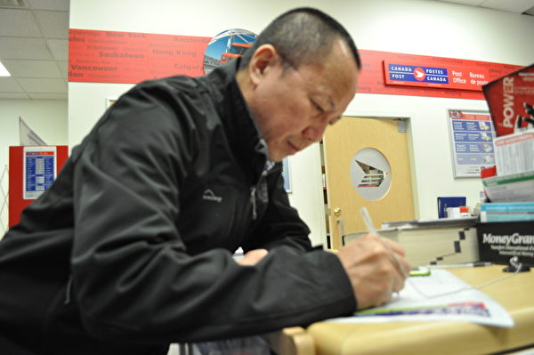 李建峰在温哥华邮局填写投递到中共高检的信件地址,加入控告江泽民的大潮中。(唐风/大纪元) 李建峰在温哥华邮局填写投递到中共高检的信件地址,加入控告江泽民的大潮中。(唐风/大纪元)
