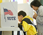 LOS ANGELES, UNITED STATES: Eight-year-old David Luu helps his mother Hui Zhang, a Cantonese speaker, read and complete her ballot at a polling center set up inside a community center in Chinatown in Los Angeles, California, 02 March 2004. California residents are voting in the "Super Tuesday" primary for the Democratic presidential nominee who will run against George W. Bush in the presidential election, as well as voting on California state budget propositions 57 and 58. AFP PHOTO / Robyn BECK (Photo credit should read ROBYN BECK/AFP/Getty Images)
