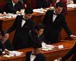 今年3月5日中共人大開幕會議上,為常委們倒茶的男服務員。(Photo credit should read GREG BAKER/AFP/Getty Images)