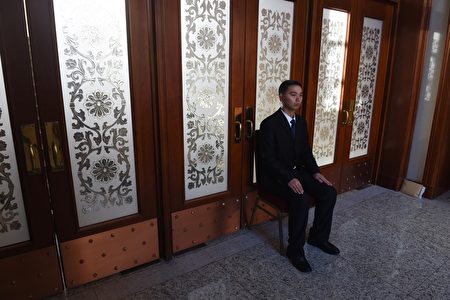 每年中共“两会”安保都异常紧张,如临大敌,会场内总有一批神秘的“黑衣人”无时无刻地在监视着一切。图为,2016年3月7日,人民大会堂内的统一穿黑西装的保安人员。(GREG BAKER/AFP/Getty Images) 每年中共“两会”安保都异常紧张,如临大敌,会场内总有一批神秘的“黑衣人”无时无刻地在监视着一切。图为,2016年3月7日,人民大会堂内的统一穿黑西装的保安人员。(GREG BAKER/AFP/Getty Images)