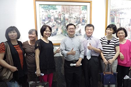 開幕茶會,湯嘉明(中)與來賓在作品前合影。(廖素貞/大紀元)