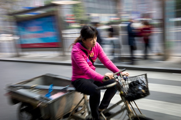 2014年10月，一名三轮车夫在北京街头骑车。（FRED DUFOUR/AFP/Getty Images）