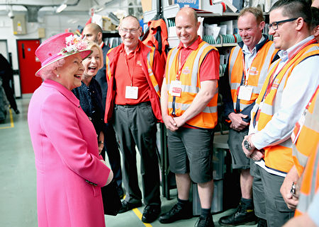 WINDSOR, ENGLAND - APRIL 20: Queen Elizabeth II shares a joke with postmen about their shorts as she visits the Queen Elizabeth II delivery office in Windsor with Prince Philip, Duke of Edinburgh on April 20, 2016 in Windsor, England. The visit marks the 500th Anniversary of the Royal Mail delivery service. The Queen and Duke of Edinburgh are carrying out engagements in Windsor ahead of the Queen's 90th Birthday tommorow. (Photo by Chris Jackson - WPA Pool/Getty Images)