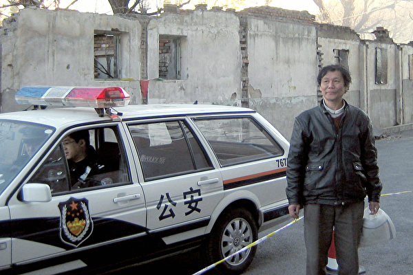 2008年11月21日，200名警察和警车包围了维权律师倪玉兰的家，推土机将这栋四合院推平。图中男子为倪玉兰丈夫董继勤。倪玉兰当时已经被抓。（ROBERT SAIGET/AFP/Getty Images）