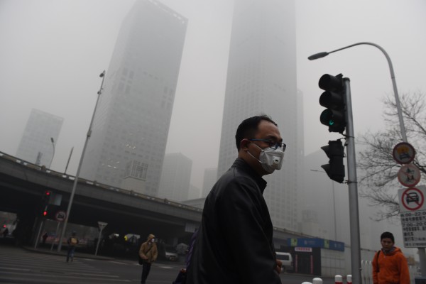 北京市环保单位称，臭氧近来已经取代PM2.5，成为该市的首要污染物。图为北京先前霾害严重时街上戴口罩的行人。（GREG BAKER / AFP）