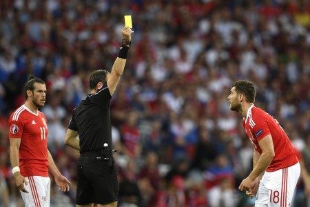 威爾斯的沃克斯(Sam Vokes)犯規吃到一張黃牌。 (MARTIN BUREAU/AFP)