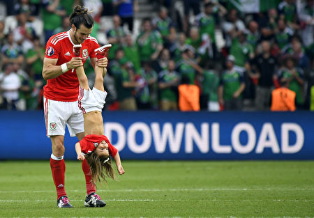 Wales' forward Gareth Bale holds his daughter Alba Viola following the Euro 2016 round of sixteen football match Wales vs Northern Ireland, on June 25, 2016 at the Parc des Princes stadium in Paris. / AFP / DAMIEN MEYER (Photo credit should read DAMIEN MEYER/AFP/Getty Images)