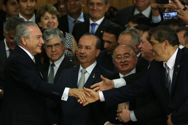 代总统泰梅尔（左）是巴西政坛元老，深知政府与国会维持良好关系是执政要务。图为泰梅尔就职代总统并签署阁员任用后，与支持者握手。(Mario Tama/Getty Images)