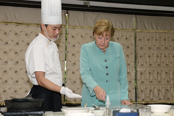 德国总理默克尔2014年访问成都期间观看怎么做宫保鸡丁。 (AFP/Getty Images)