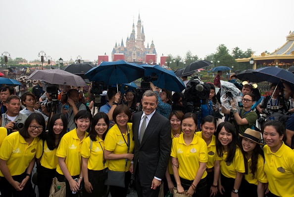上海迪士尼乐园6月16日在雨中正式开幕，图片正中为迪斯尼公司董事长兼CEO艾格（Bob Iger）。（JOHANNES EISELE/AFP/Getty Images)